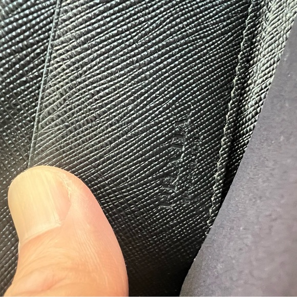 snap-hook and ring
Zipper closure
Enameled metal triangle logo
Two card slots - Picture 9 of 11